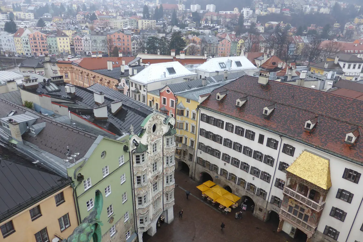 Rooftops and colourful house fronts of Innsbruck's Old Town seen from above, with the Golden Roof at the right